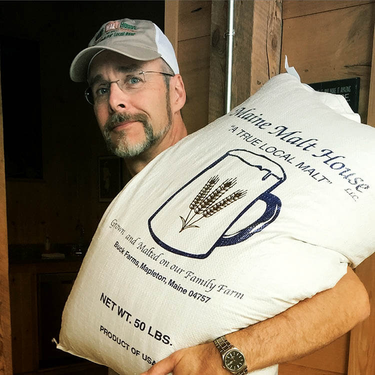 Jeff Powers of Bigelow Brewery carrying a bag of malt grain